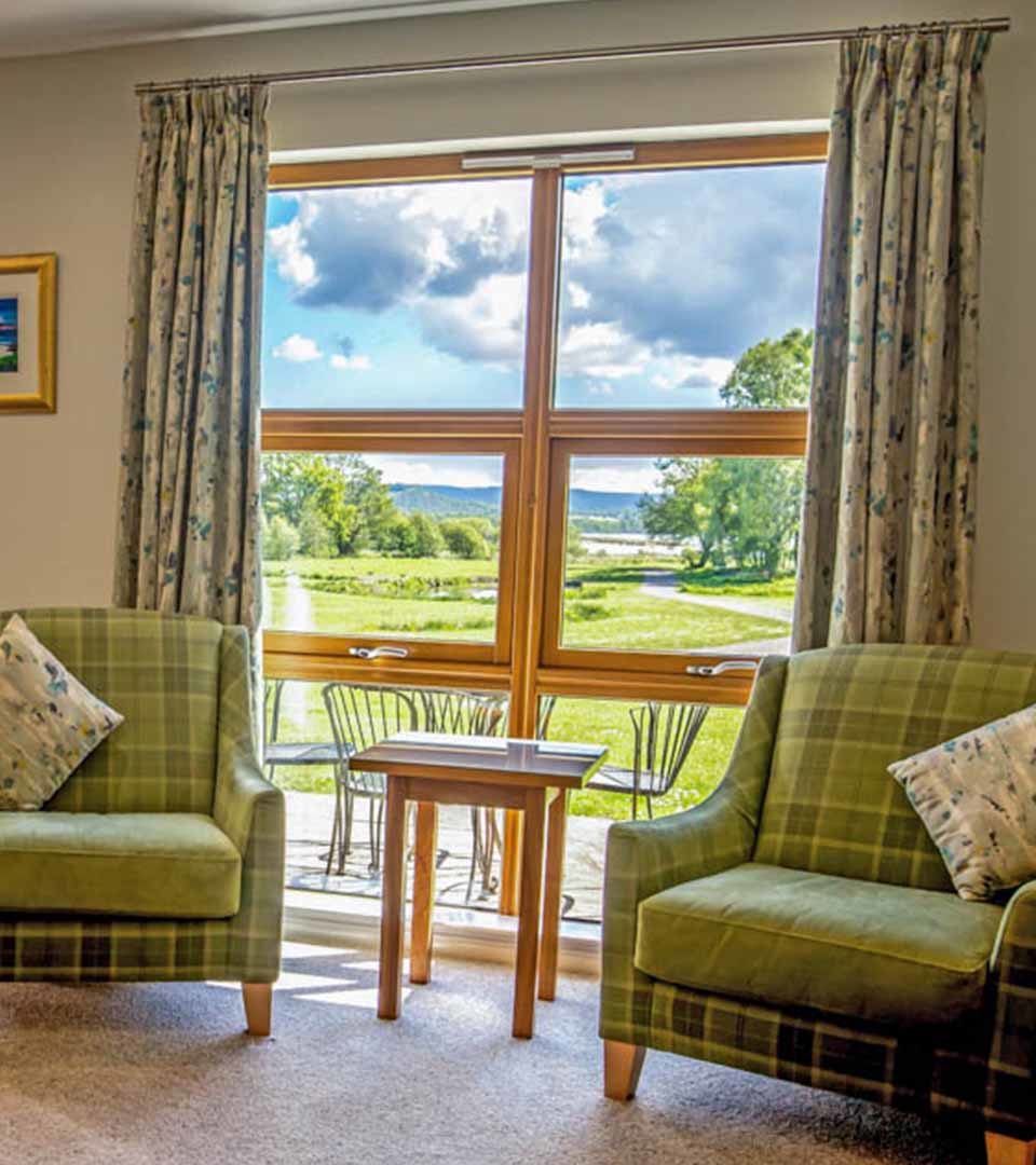 Two armchairs with a stunning view out to Loch Lomond in a Diamond Lodge at Loch Lomond Waterfront