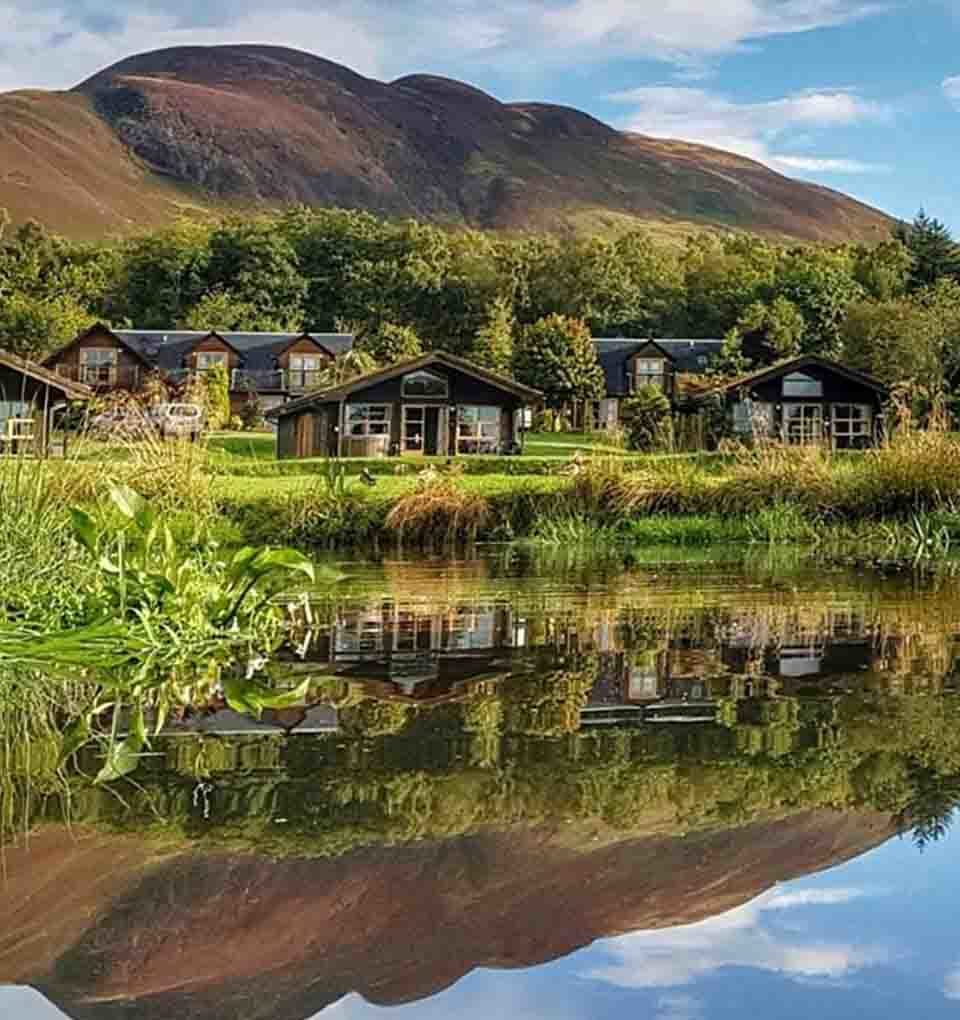 A view of the Loch Lomond Waterfront Lodges over still water