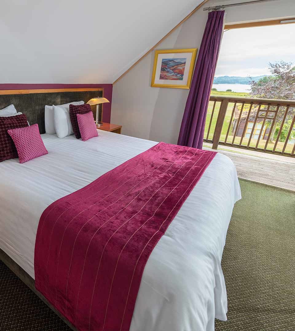 A double bedroom with a balcony and view of Loch Lomond at Loch Lomond Waterfront