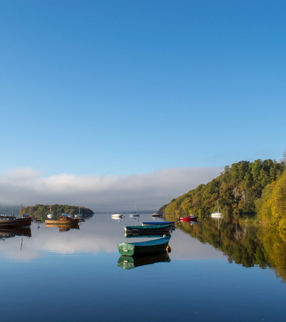 Boats in calm water in the bay at Balmaha