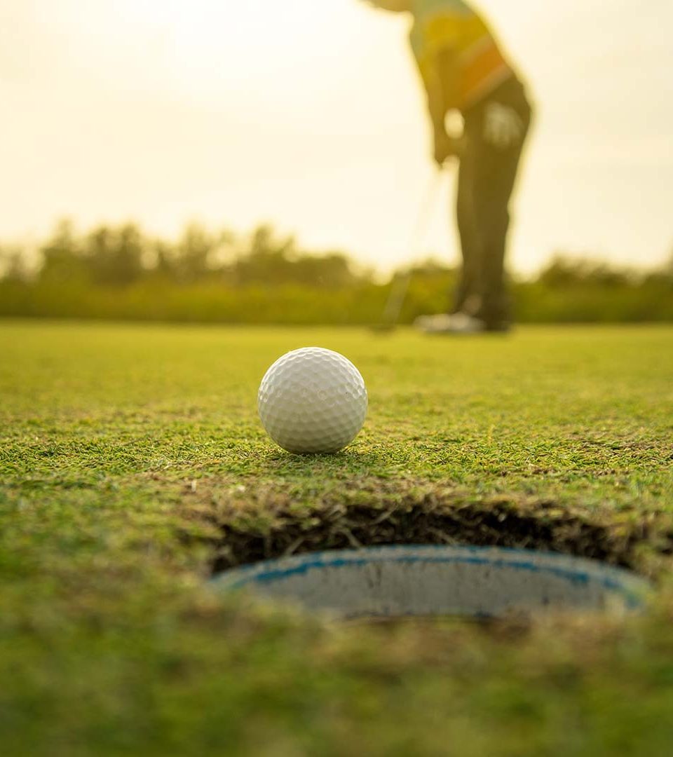 a golfer putting a ball