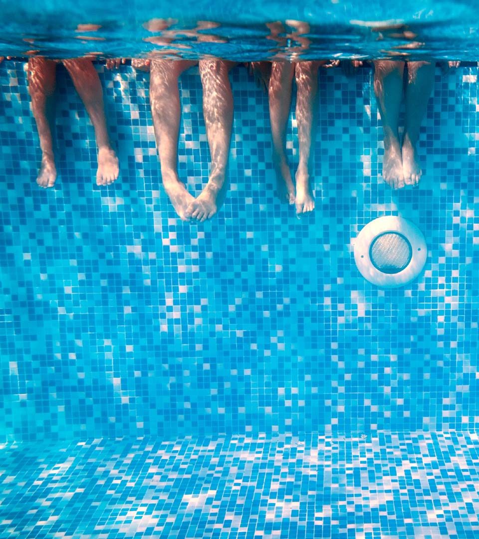 Family with legs underwater in swimming pool