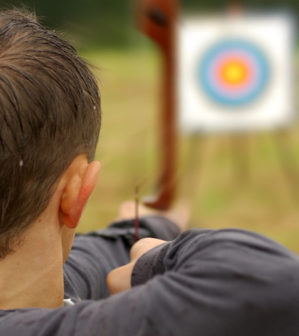 A boy doing archery with In Your Element at Loch Lomond