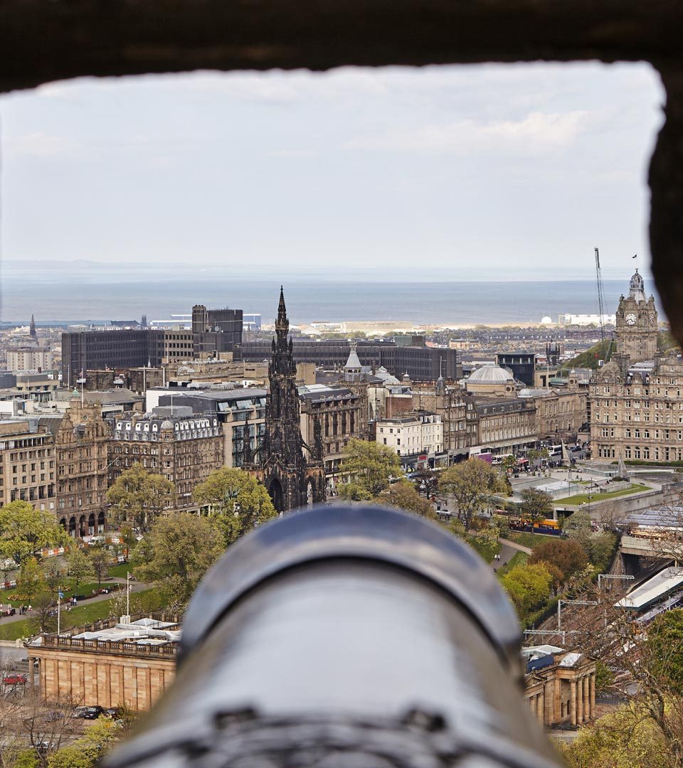 View of Edinburgh skyline through canon and window at Edinburgh Castle