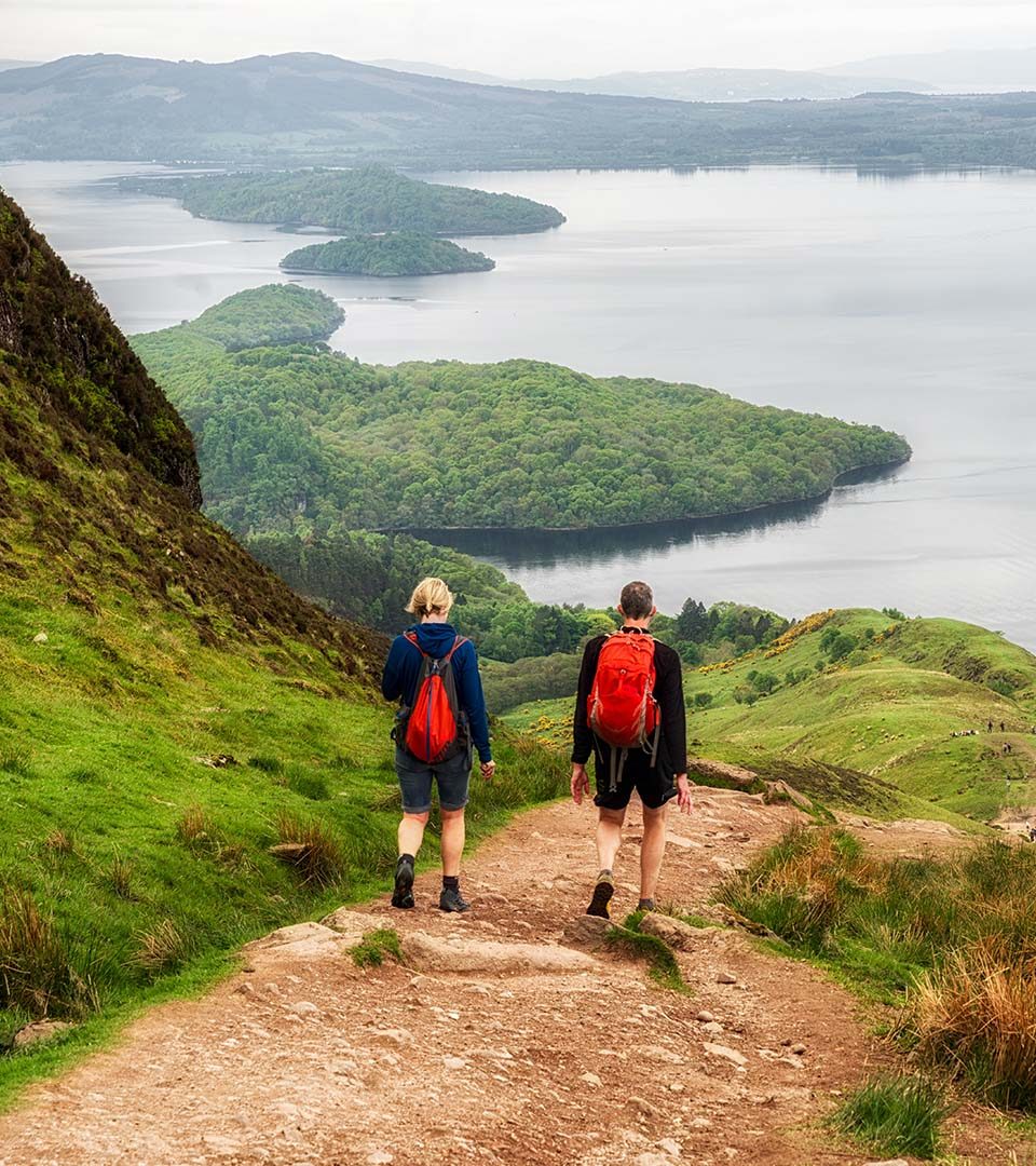 Two walkers descending Conic Hill in Balmaha