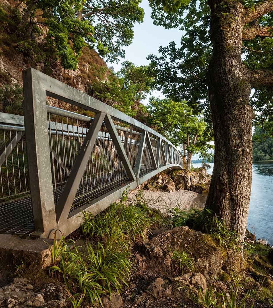 A metal bridge on a walkway by Loch Lomond in Balmaha