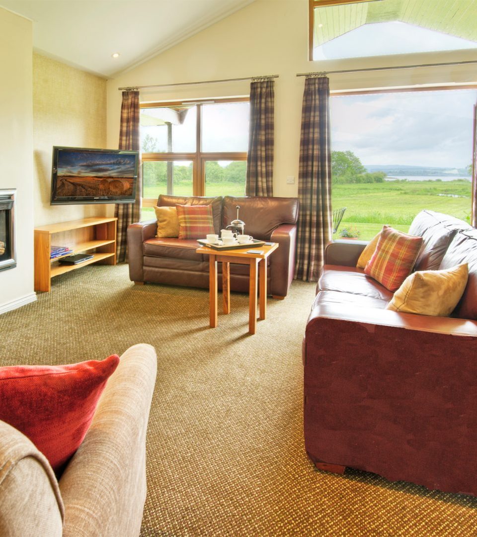 The interior of a luxury chalet looking out over Loch Lomond and its private hot tub