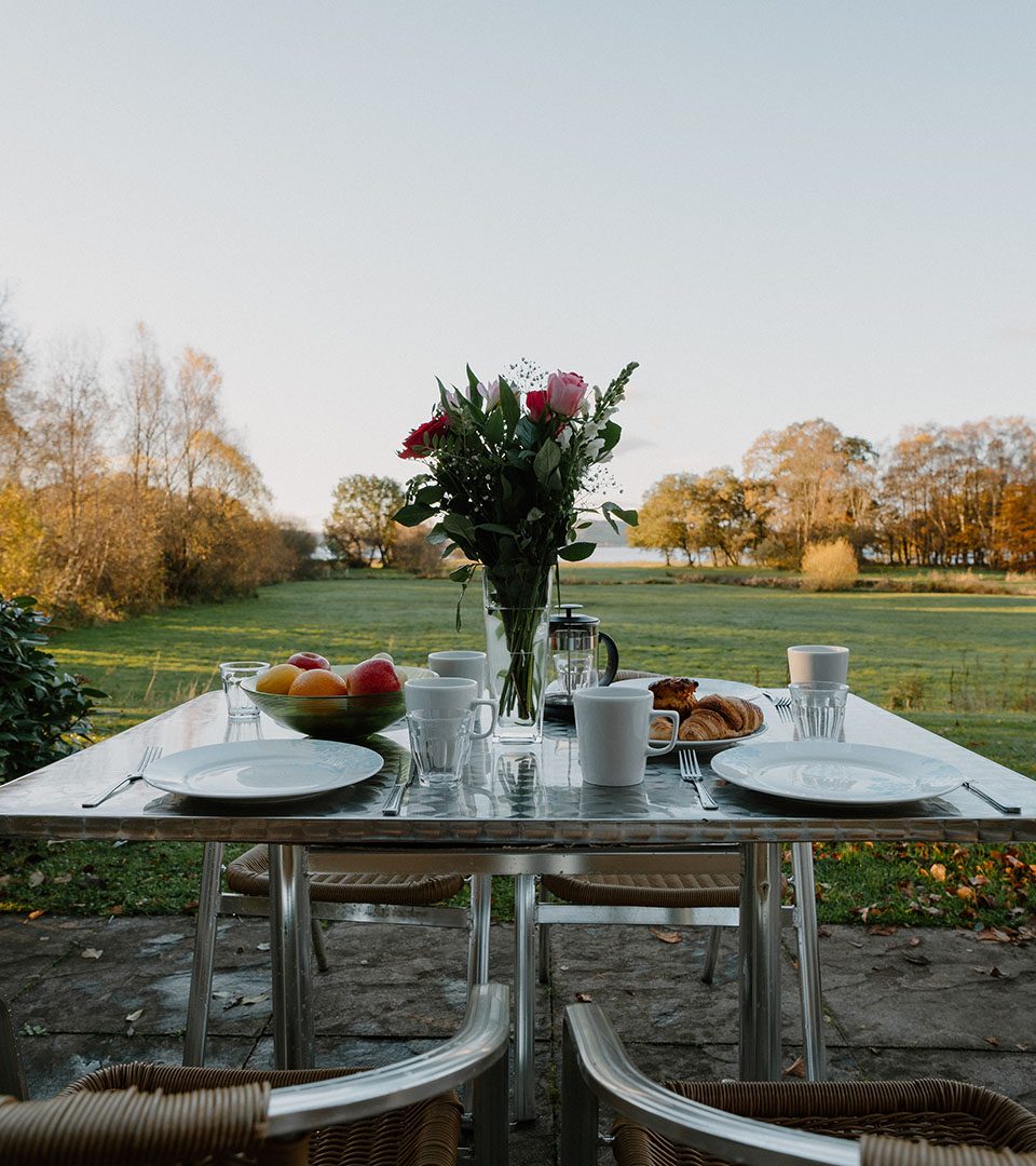 A table set up for Al Fresco dining outside a Diamond Lodge at Loch Lomond Waterfront luxury lodges in Balmaha