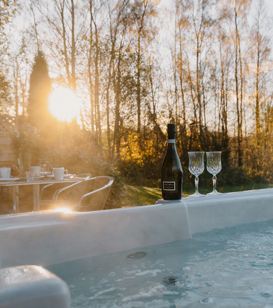 Champagne at sunset by a hot tub at a Diamond Lodge at Loch Lomond Waterfront luxury lodges in Balmaha