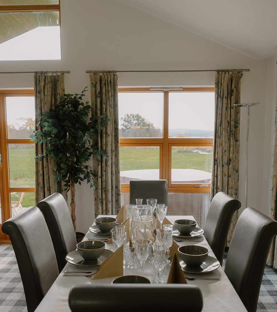 A dining table set for dining in a chalet at Loch Lomond Waterfront luxury lodges in Balmaha