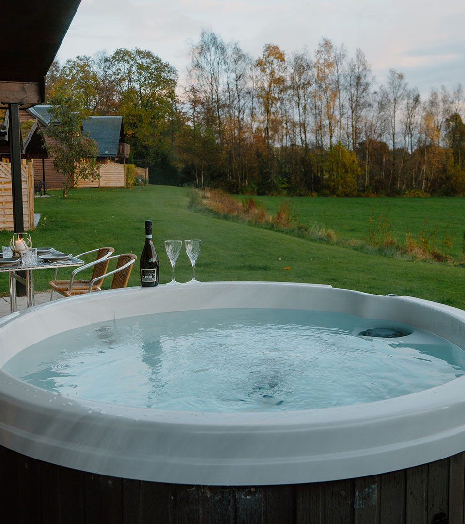 A hot tub with champagne at Loch Lomond Waterfront luxury lodges in Balmaha