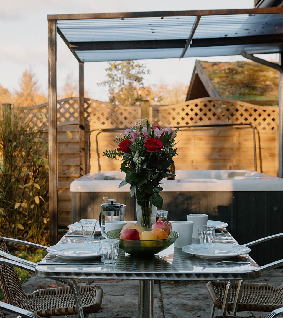 A table set for dining outside at a Diamond Lodge at Loch Lomond Waterfront luxury lodges in Balmaha